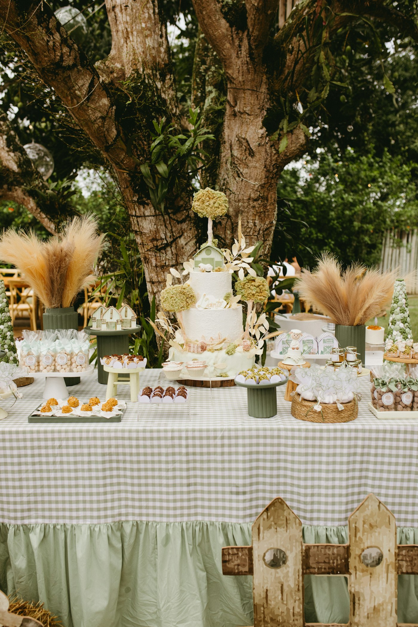 Mesa de doces de aniversário infantil montada ao ar livre sob uma árvore