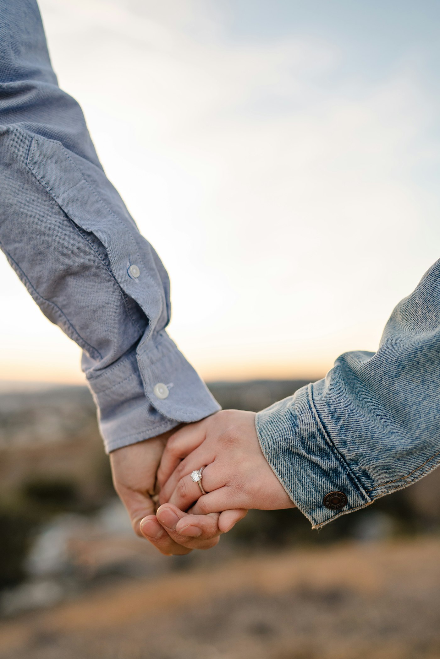 Mãos de um casal entrelaçadas em um momento de celebração