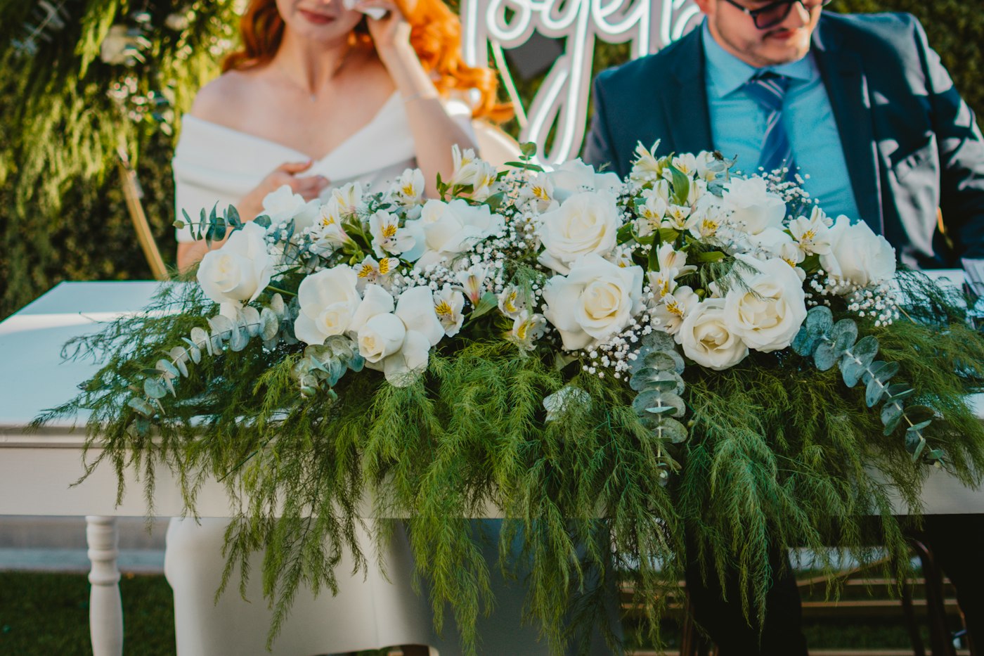 Casal durante a assinatura do casamento em uma cerimônia com flores