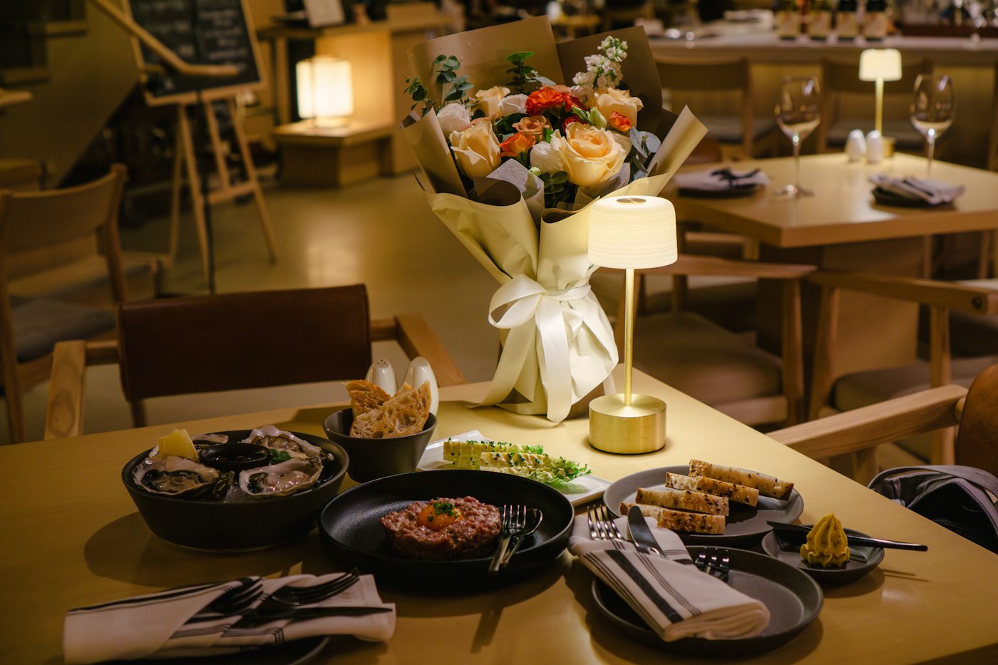Mesa posta para um jantar íntimo, com flores e luz suave